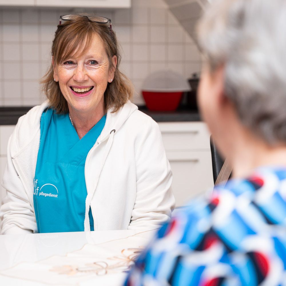Pflegekraft lacht mit Klientin