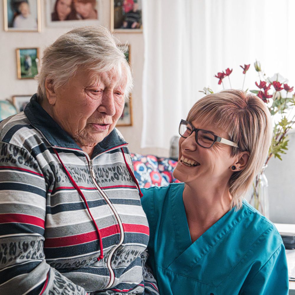 Pflegekraft und Klientin lachen gemeinsam